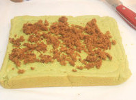 5、抹茶戚风肉松卷,撒上肉松（可以先铺一成沙拉酱），用擀面杖辅助卷成卷。静置30min，放凉后即可切块。