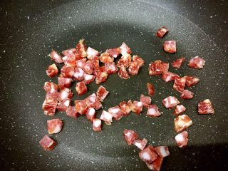 5、腊肠粒黄金炒饭,中火热锅，锅热后转小火，把腊肠粒放进去稍煎一下