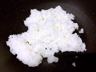 8、腊肠粒黄金炒饭,把米饭倒进锅里