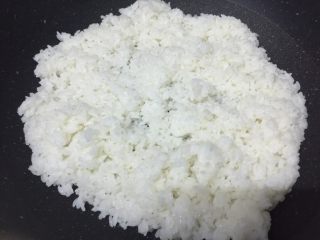 10、腊肠粒黄金炒饭,把米饭平铺在锅面