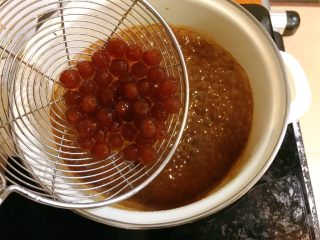 17、黑糖珍珠奶盖奶茶,把凉水中的珍珠过至黑糖浆中。