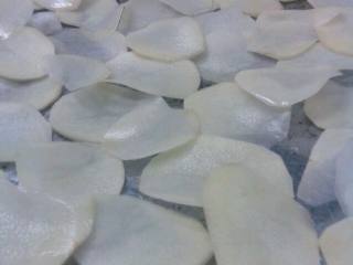 3、李师傅 自制薯片,烤箱加热后关掉留有余热 将翘起来的土豆片摆入烤盘 (土豆片尽量不要重叠)