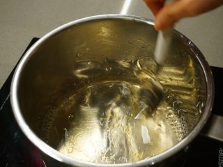 1、千层椰汁桂花糕,把浸软的鱼胶片放入热水中，轻轻搅拌使其彻底融化