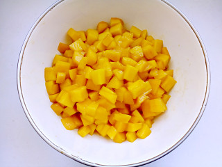 3、平安夜淋面蛋糕,将芒果去皮切丁。