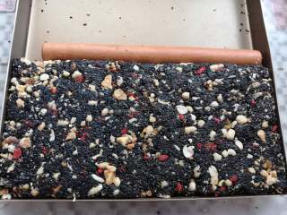 14、核桃花生芝麻糖,翻拌好的糖放入不沾金盘里沿着金盘边缘的高度整形