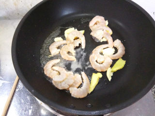 6、五彩虾仁,锅中倒入少许植物油，烧热，下入虾仁和姜片，以及蒜碎。