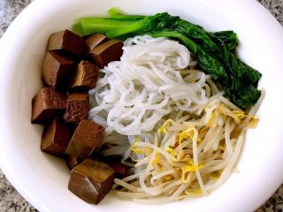 5、鸭血粉丝汤,处理好的粉丝放入容器中再将鸭血和时蔬摆在上面