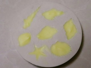1、海洋系列酸奶盒子,取大约15克的白巧克力，隔热水融化，倒入贝壳硅胶模具中，放入冰箱冷冻一个小时以上，取出脱模备用。