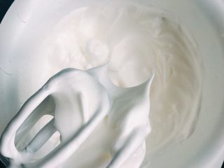 11、吃起来满口幸福感的蔓越莓戚风蛋糕,直至出现小弯钩的时候加入剩余的糖粉，继续沿内壁高速打发。