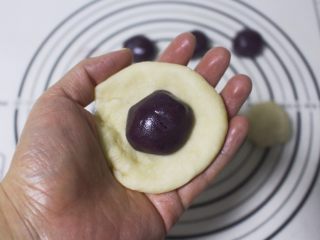 6、旋风紫薯油酥烧饼,取油皮一个按扁，包入一个油酥，然后捏紧边缘，最后滚圆