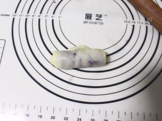 8、旋风紫薯油酥烧饼,取包好的剂子，用擀面杖擀成牛舌状之后，从下往上卷起来