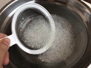 6、芒果椰汁西米露,利用漏筛捞起西米沥干水，倒进预先冷藏过的凉开水里，利用一冷一热的交替，使得西米口感更加Q弹，熟而不烂