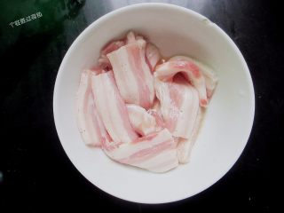 3、雪碧五花肉,把五花肉放入碗里，倒入适量雪碧和一点点黑胡椒粉腌制一小时