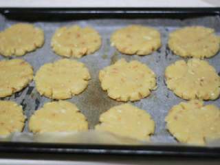 8、教你做简单的桃酥,放在掌心，两手一按，桃酥那种自然的裂纹就出来了， 刷蛋液，蛋液里少加一点点水，烤出的成品颜色会更漂亮哦