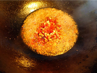 6、爆炒鸡杂,将油烧至6成热，放入几粒花椒炒香，铲出不用，放入一小勺豆瓣酱，炒香，加入剁细的泡姜泡椒末翻炒均匀。