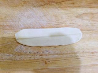 3、油泼扯面,1小时后面团变得非常柔软，将面团擀薄，用筷子在中间按一下。