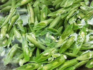 7、四季豆炒腊肠,倒入四季豆。