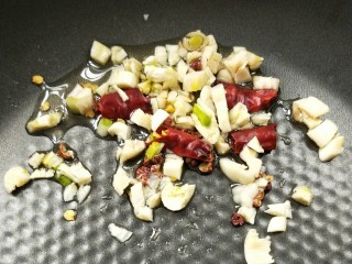 9、四季豆炒腊肠,起油锅,放少许油,放干辣椒,花椒粒,蒜末小火煸炒。