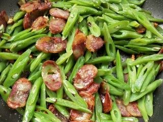 13、四季豆炒腊肠,翻炒均匀加生抽,盐,鸡精调味。