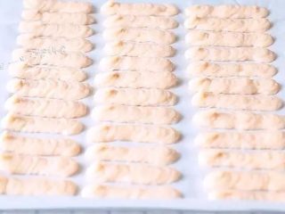 6、自制虾条,挤的时候裱花袋跟烤纸垂直，裱花袋的口不要紧贴烤纸，离烤纸一点距离，一边挤一边移动，这样挤出来的虾条比较饱满。