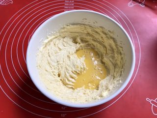 7、果酱饼干,蛋液分三次加入黄油盆，加入第一个三分之一的全蛋液，打匀。