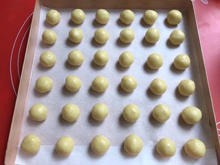 14、果酱饼干,搓成36个小球，放入铺了油纸的烤盘里。