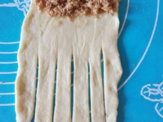 5、毛毛虫肉松面包,在面块最上方涂抹一层沙拉酱，再均匀放上肉松，最后将面块中下部分用刀切成小条。