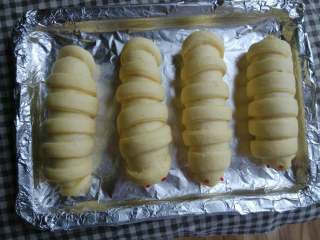 8、毛毛虫肉松面包,可以将发酵好的面包表面均匀刷上一层蛋液，烤出来的面包颜色会更漂亮，再撒上适量芝麻(我家正好没芝麻了所以我没放)。