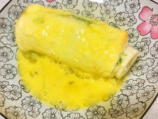 7、辅食10M➕ 香蕉牛油果吐司卷,将蛋液均匀包裹上卷起的牛油果香蕉吐司卷