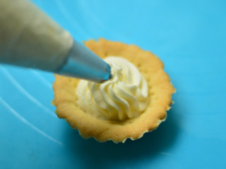 12、圣诞帽子塔,将打发好的奶油放入装好裱嘴的裱花袋，等塔皮凉透后，挤上奶油