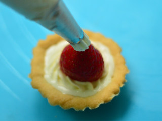 13、圣诞帽子塔,草莓切去底部，放在奶油上，形成帽子的形状，在草莓顶部挤上少许奶油