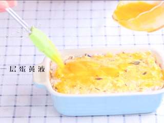 4、黄金米糕,取出来刷一层蛋黄液，继续盖保鲜膜蒸10分钟。