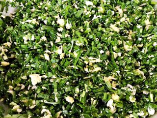 4、飘香韭菜盒,先用油把韭菜和鸡蛋拌好再放入虾皮、盐和味精、香油拌匀