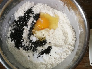 4、年味～花式炸麻叶,打入鸡蛋，加入盐和黑芝麻，搅拌均匀