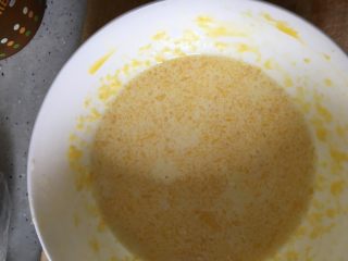 4、蔓越莓蛋挞,将有牛奶的料慢慢倒入蛋黄里搅拌均匀