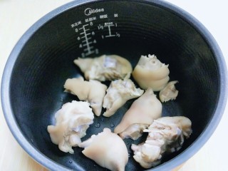 6、黄豆猪脚汤#电饭煲版#,加入泡好的薏米和黄豆。焯水并洗干净的猪脚加入电饭煲中。