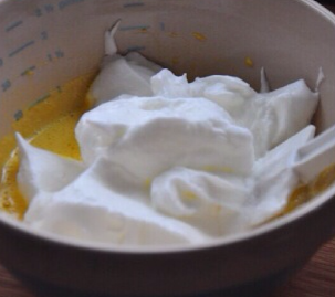 4、小山卷,取半量打发蛋白与蛋黄液混合均匀，注意手法，以翻拌或切拌手法拌匀