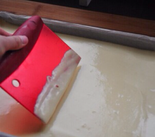 11、小山卷,用塑料刮板将面糊整理至高度一致表面平整，四角可以刮板自45度切入方式将面糊铺满