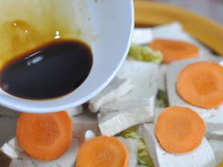 10、五花肉豆腐锅,生抽、蚝油混合,均匀的淋在菜上。