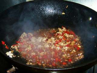 6、肉末酸豆角,加入料酒 酱油 糖继续煸炒均匀。