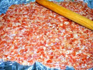 3、猪肉脯,在案板上铺上锡纸,倒上肉末铺平,然后盖上一层保鲜膜,用擀面杖把肉擀成2厘米厚的肉片