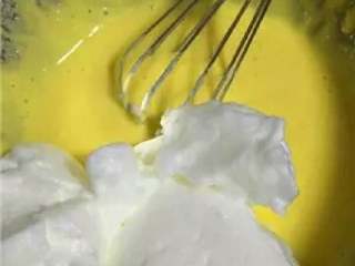 9、酸奶戚风蛋糕,分三次将蛋白加入面糊中,上下翻拌均匀