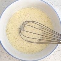 2、芒果千层蛋糕,加入牛奶搅拌均匀。