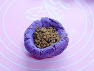 10、补血养颜～低脂紫薯红糖糯米饼,取一块面团，包上红糖！将收口捏紧揉圆！