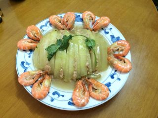 10、爱心虾冬瓜扣,从蒸锅里拿出，把汁倒出碗里，把盘放到冬瓜扣上面迅速翻转，把冬瓜扣倒进另一个盘中，煮计勾芡，淋到冬瓜扣上面，这样就光滑，煮熟的虾摆在冬瓜扣的傍边，爱心虾冬瓜扣就完成了。