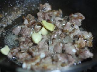 5、蔓越莓烧排骨,放入冰糖和姜蒜，翻炒至冰糖融化