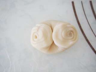 11、玫瑰酥饼,将面团用手指在中间压一下，两端往中间收，然后压扁。