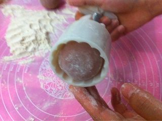 12、冰皮月饼,月饼模具里撒些熟干粉 ，把面团放入月饼模中。1