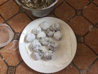 17、酥炸鱼球,然后放在生粉碟中轻轻滚动,使鱼丸表面裹上一层薄薄的生粉