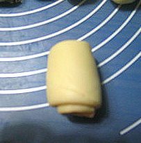 14、香酥板栗饼,旋转90度,再次擀开,擀成长条状。再卷起。